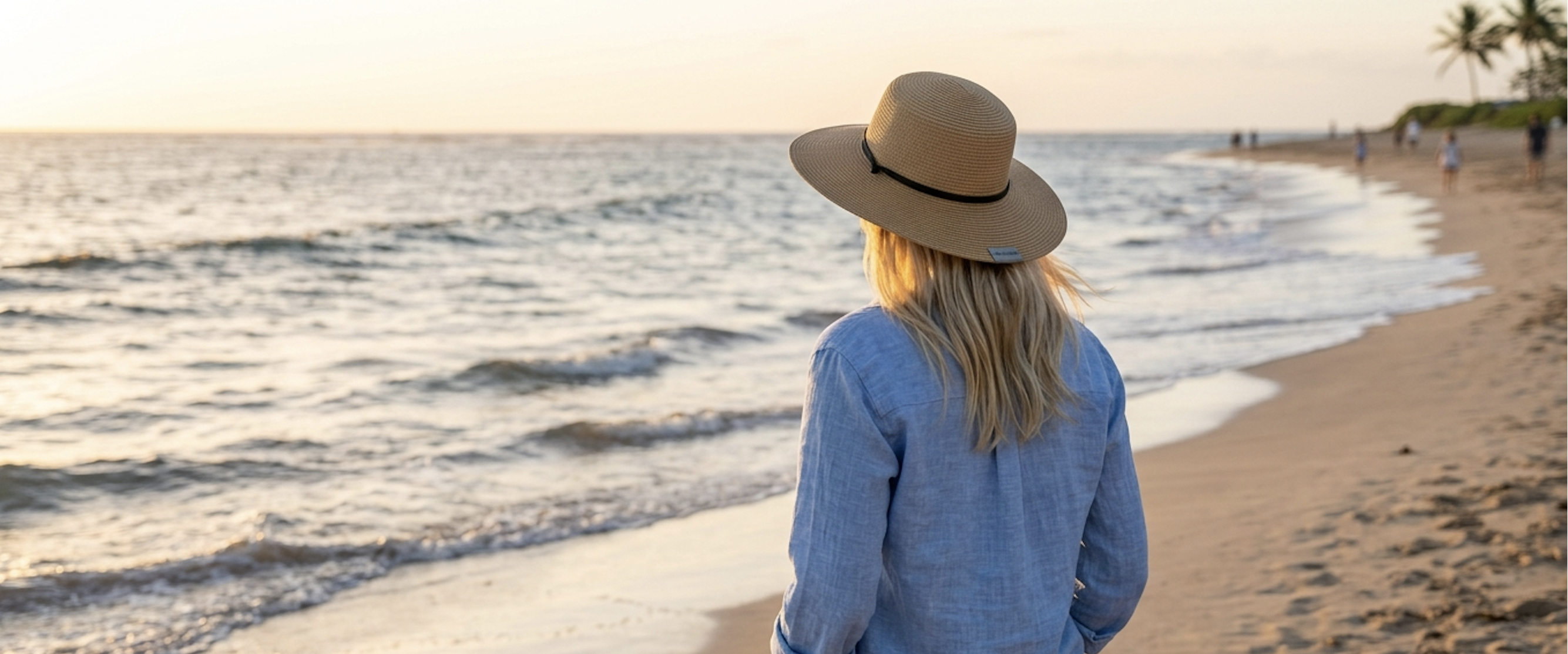 Woman wearing a packable travel hat on the beach